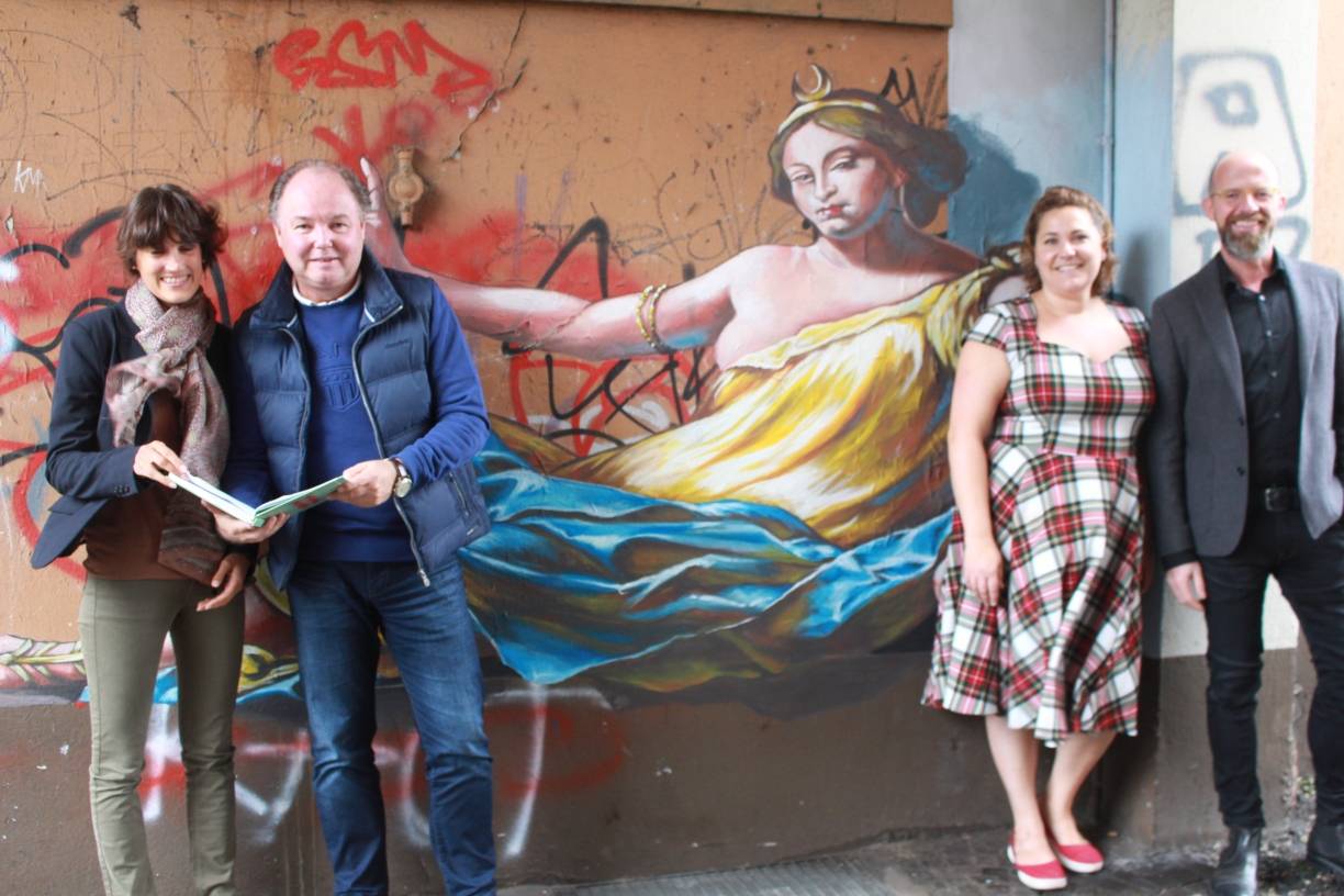  Künstlerische Kulisse: Marketingchef Uli Cloos (r.) und Gastronomin Christine Tessier (r.) freuen sich über den großen Zuspruch der Besucher. Uwe Rutkowski (l.), Vorsitzender des Uerdinger Kaufmannsbundes, zeigt Claire Neidhardt vom Marketingamt (l.) das Gästebuch voller begeisterter Einträge. 