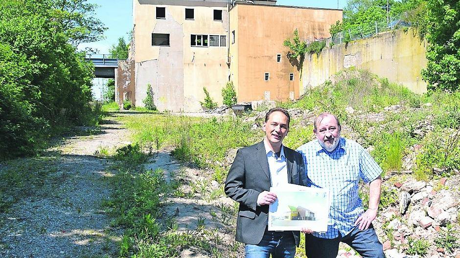 Bernd Piplack und Wolfgang Gebhard stehen auf dem Schutthaufen, auf dem ein Nahversorgungszentrum gebaut werden könnte.