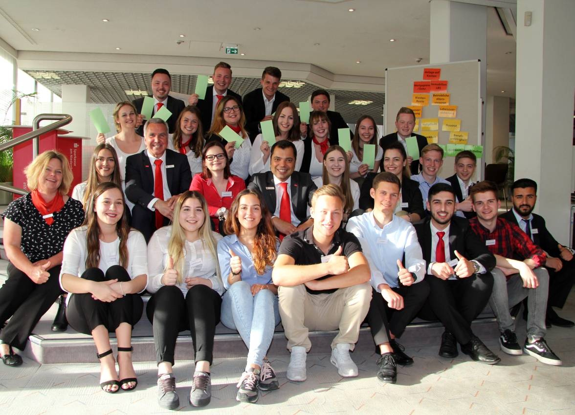 Die 15 neuen Auszubildenden der Sparkasse am Niederrhein erlebten einen ebenso lustigen wie spannenden Infoabend. Vorstandsvorsitzender Giovanni Malaponti (Mitte) sagte, „wir freuen uns wie Bolle auf Sie“. Auszubildende aus dem 3. Lehrjahr, die eine Modenschau und einige Theaterszenen präsentierten, zeigten die grüne Karte dazu.