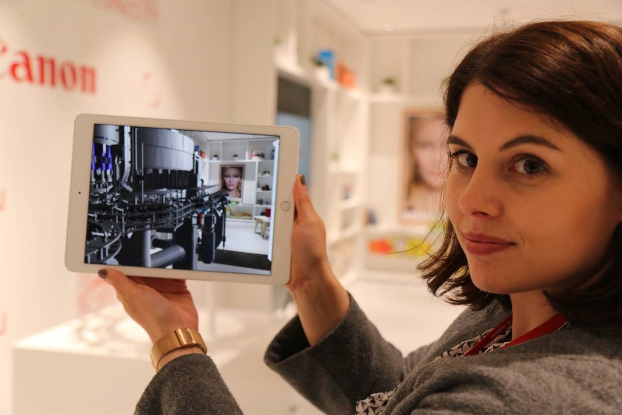  Anschaulich: Wie „virtuel reality“ funktioniert, demonstriert Kommunikationsmitarbeiterin Sarah Stuwe im Customer Experience Center. Ihr Tablet bildet den realen Raum ab, doch in das Bild hinein projiziert sie eine virtuelle Maschinenanlage. 