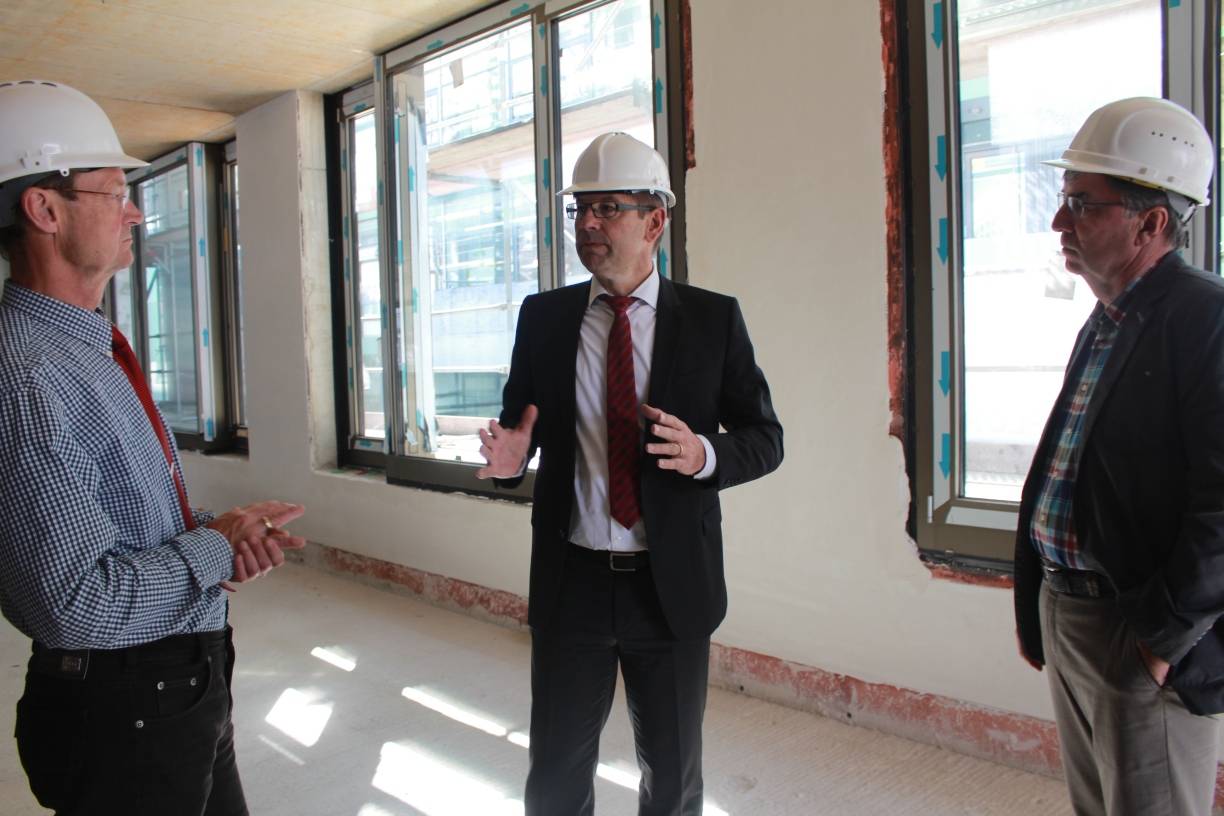  Rundgang: Hausherr Thomas Siegert erläutert den Vertretern des Wohnstätten-Aufsichtsrats, Jürgen Hengst (SPD, l.) und Jürgen Wettingfeld (CDU, r.) den Baufortschritt. 