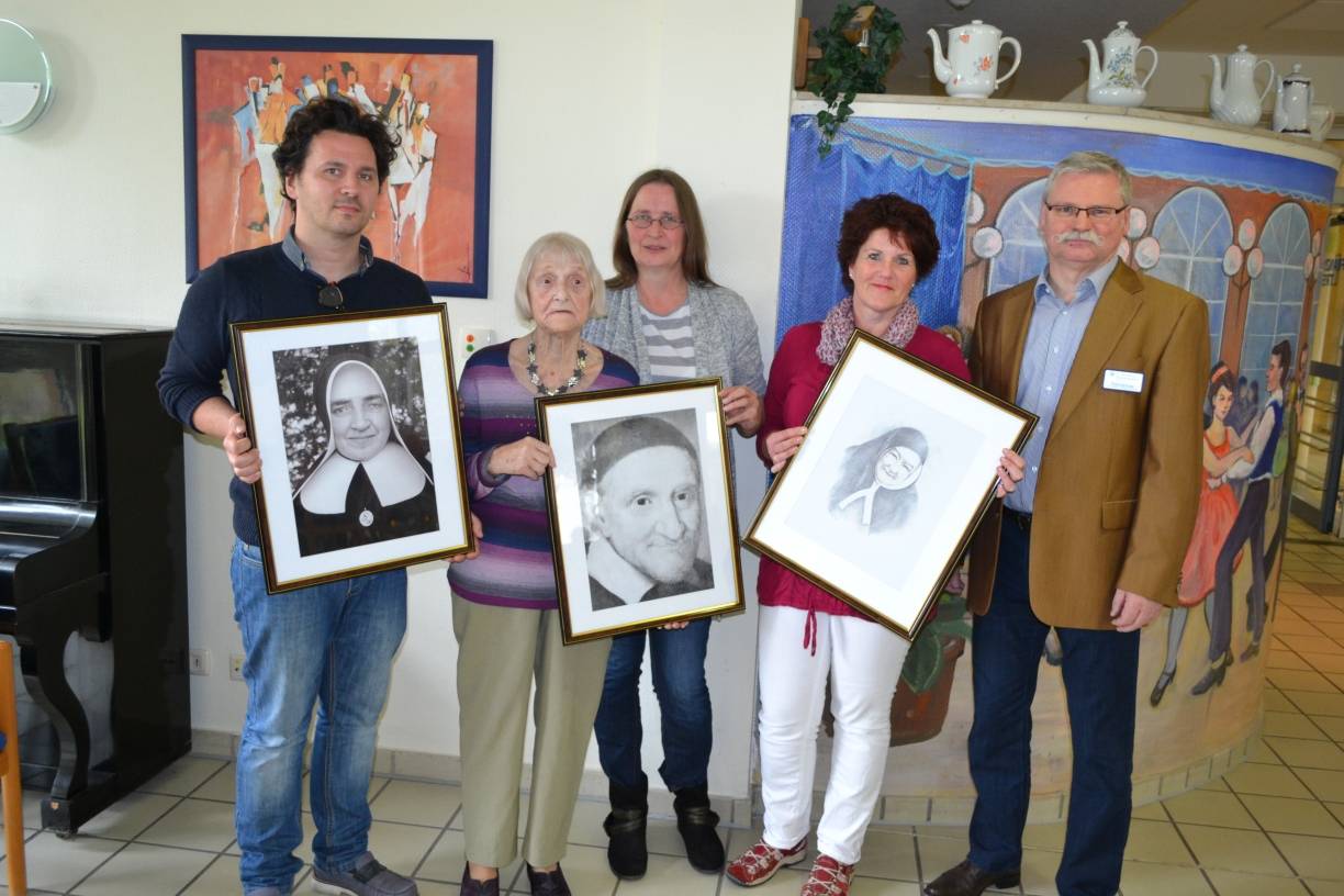  Im Beisein der Bewohner überreichte Einrichtungs- und Pflegedienstleitung Winfried Kopp den Wohnbereichsleitungen (v.l.) Klaudius Szczepaniak, Andrea Schacht und Brigitte Baumann, sowie Bewohnerbeiratsvorsitzende Inge Gilges die Porträts der Namensgeber für die Wohnbereiche. 