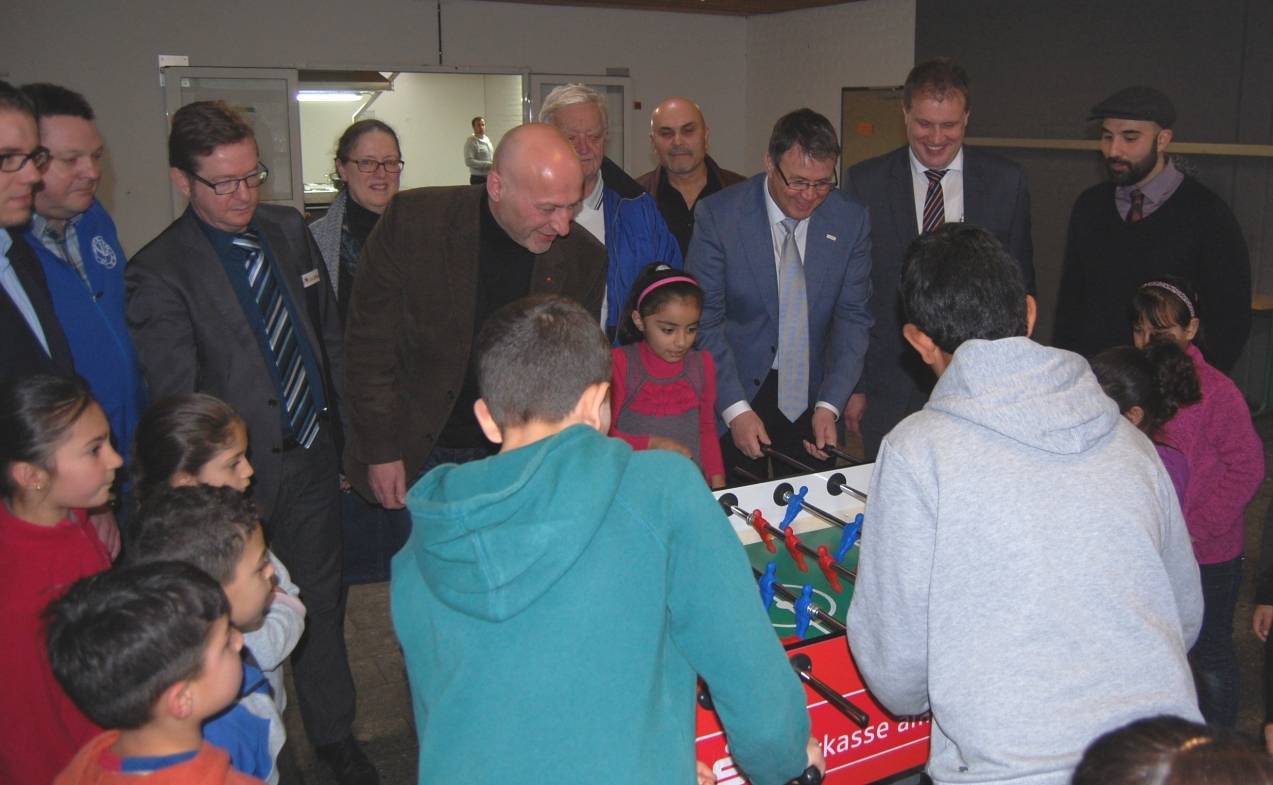 Der Landtagsabgeordnete Ibrahim Yetim und Uwe Goemann, Geschäftsführer der Vivawest Stiftung, kickern mit den Kindern in der Unterkunft Am Meerholz.