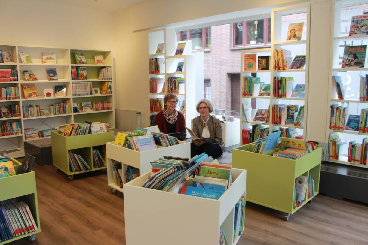Neu gestaltete Räume: Die ehrenamtlichen Büchereileiterinnen Maria Feldhoff (l.) und Katja Vornhusen (r.) freuen sich, jetzt viel Platz für Wühltische und Sitzbänke in kinderfreundlicher Höhe zu haben. Die Kinder- und Jugendabteilung ist der Schwerpunkt der Hülser Bücherei. Die Jugendlichen mögen besonders Bücher aus den Bereichen Fantasy und Spannung. Bei den Erwachsenen sind Krimis und Familiensagas die Renner. Im hinteren Teil des Hauses ist auch eine Sachbuchabteilung untergebracht. Insgesamt stehen 10.000 Medien bereit. Im vorigen Jahr verzeichnete die Bücherei rund 72.000 Ausleihen. Ein Mitgliedsausweis kostet 9 Euro im Jahr.