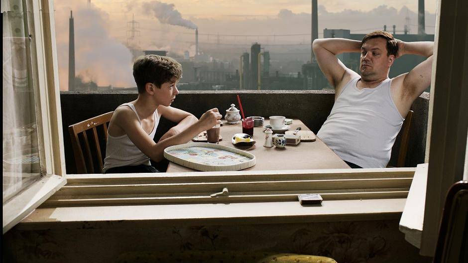 Julian (Oscar Brose) und Vater Waller (Charly Huebner) beim Frühstück auf dem Balkon.