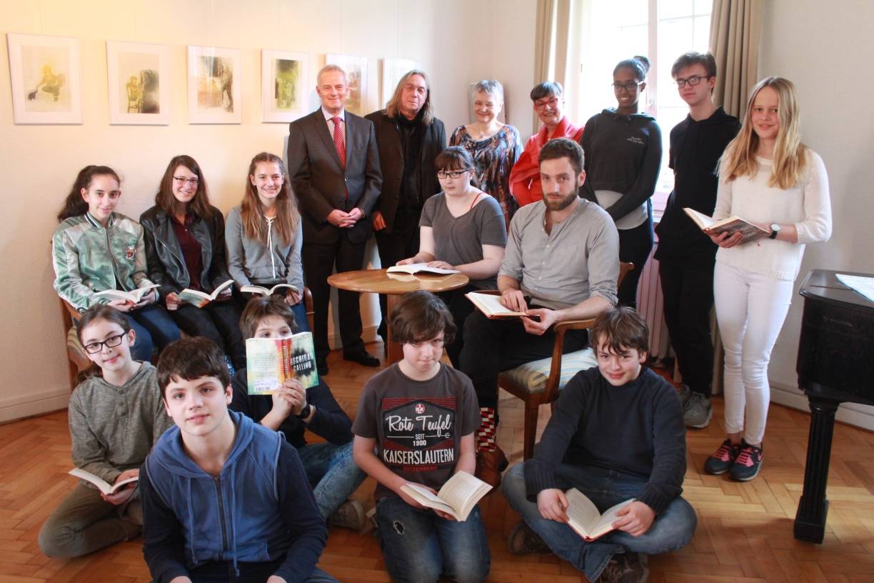 Eifrige Leser: Die Jugendlichen versammeln sich im Niederrheinischen Literaturhaus an der Gutenbergstraße um Clubleiter Dorian Steinhoff (sitzend). Zu Besuch sind diesmal: (v.l.) Michael Rotthoff von der Sparkassenkulturstiftung, Kulturbüroleiter Jürgen Sauerland-Freer, die Vorsitzende des Kulturausschusses im Stadtrat Ingeborg Müllers sowie Anette Ostrowski, die Leiterin des Literaturhauses.