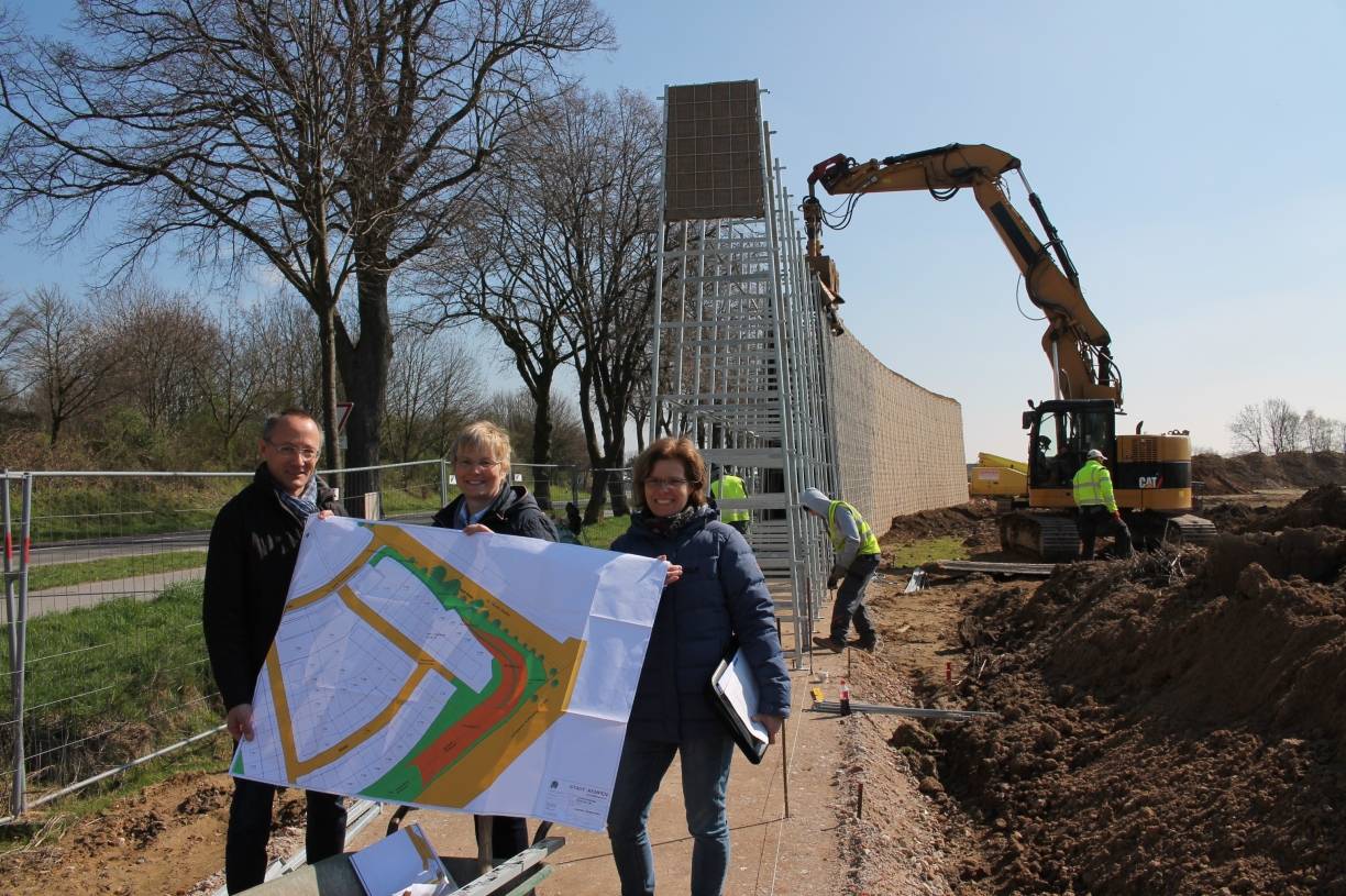  Klaus Herrmann (stellvertretender Leiter Grünflächenamt), Patricia Schürmann (Amtsleiterin Grünflächenamt) und Gertrud Klinger (Tiefbauamt, Bauleiterin Erschließung) vor der Lärmschutzwand, die schon Ende nächster Woche fertig sein soll. 