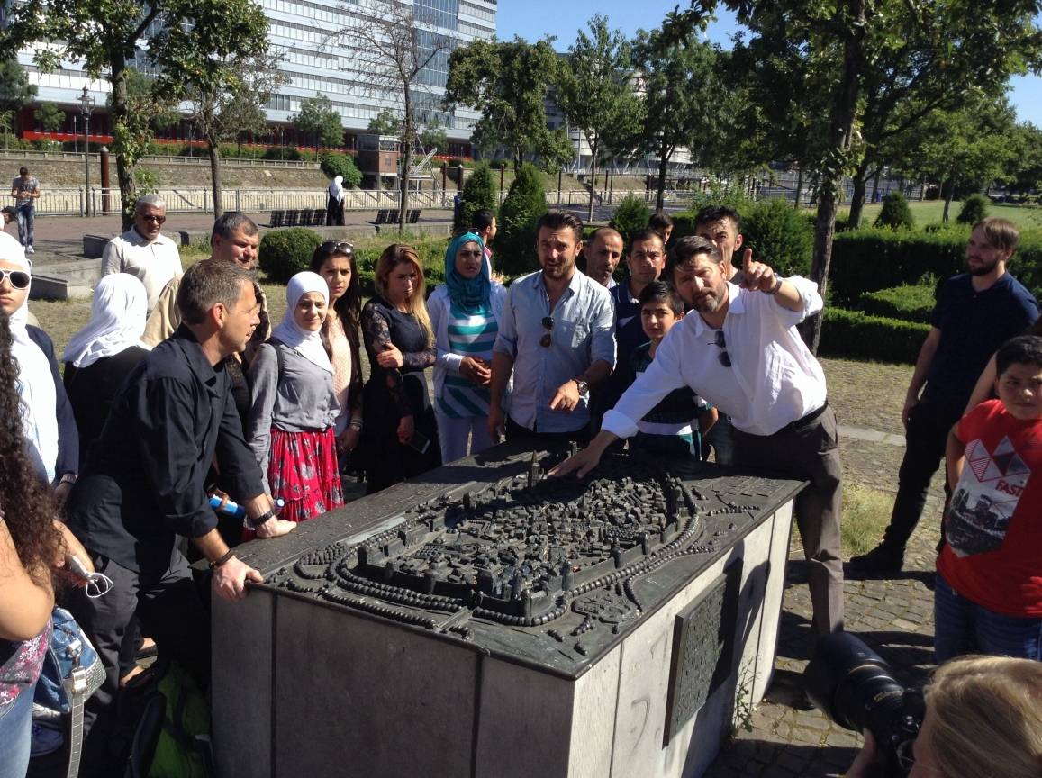 Kai U. Homann, mit dem Zeigefinger in Richtung stadthistorisches Museum, zeigt anhand der Miniatur den aktuellen Standpunkt.