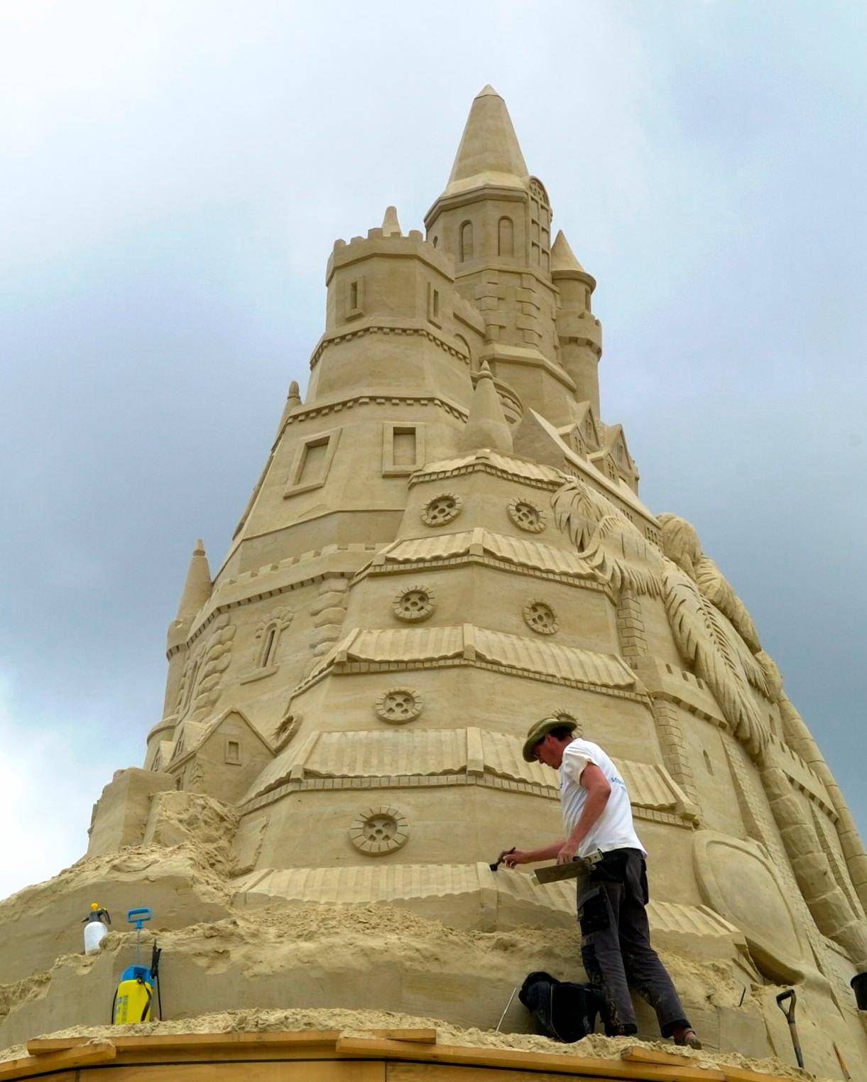 Rund ums "Bauwerk" verteilt, sieht man Sandkünstler bei der...