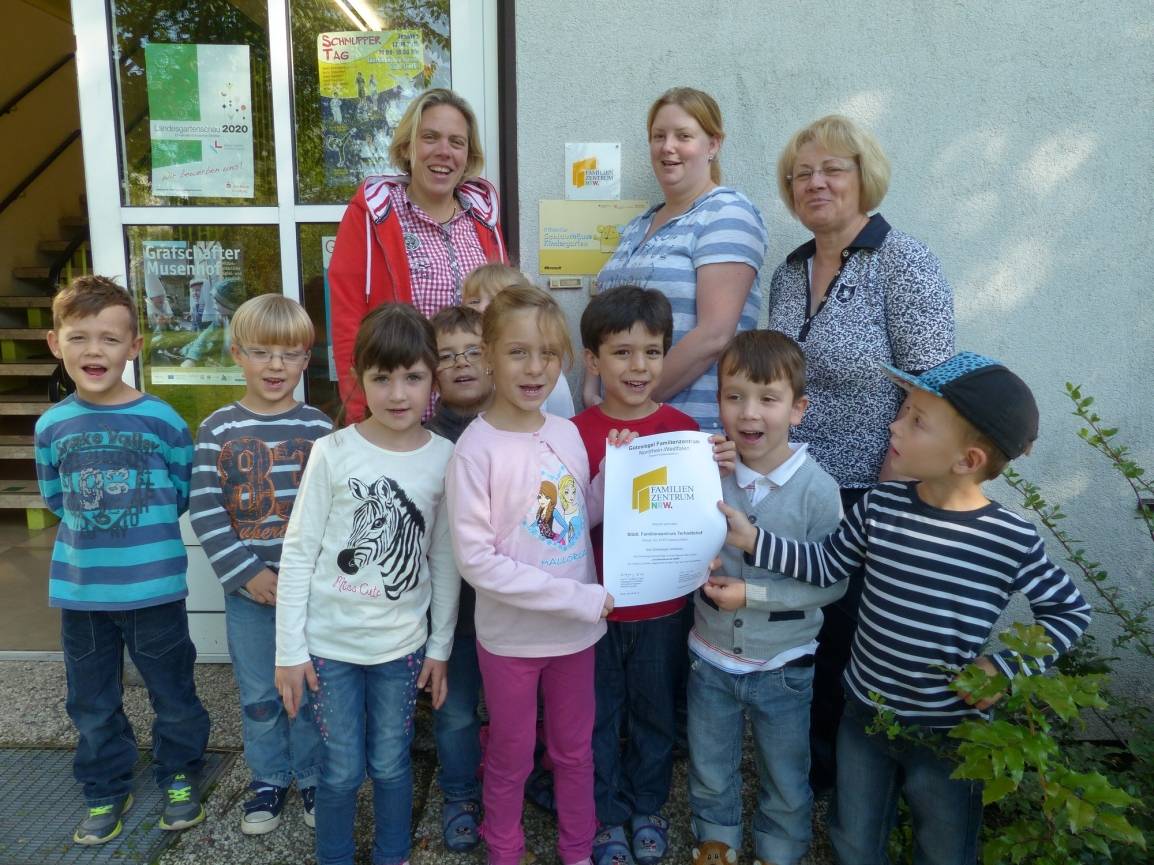 Kita-Leiterin Alexandra Krause, ihre Mitarbeiterinnen Desiree Reiners und Aldona Vopersal (v.l.n.r.) und die Kinder sind stolz auf die Rezertifizierung.