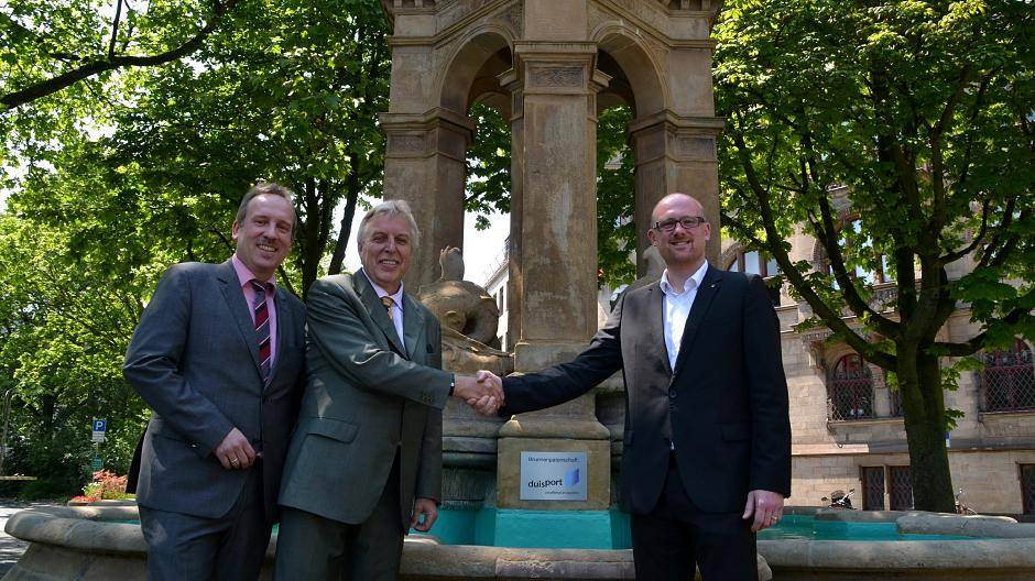  Stadtentwicklungsdezernent Carsten Tum, duisport-Chef Erich Staake und Oberbürgermeister Sören Link vor dem Mercatorbrunnen mit nagelneuer Patenschaftsplakette.  