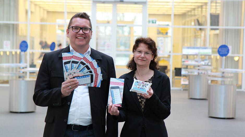 Ulrike Holz von der Zulassungsstelle des Straßenverkehrsamt und Jürgen Brings von der Presse- und Öffentlichkeitsarbeit machen mit Schwämmen und Flyern auf die Online-Angebote des Rhein-Kreises Neuss aufmerksam.