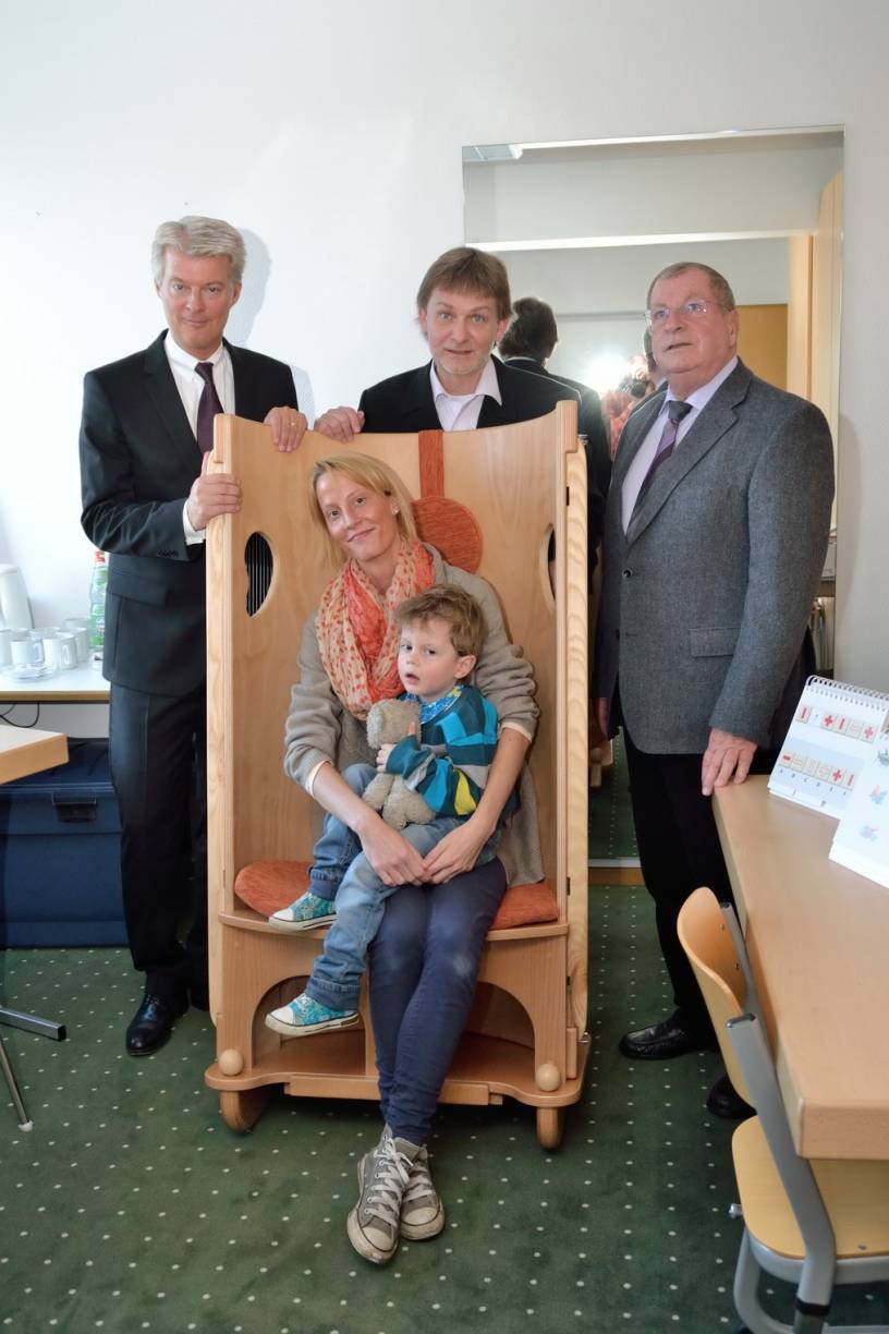 Während Mutter Nadine zusammen mit Ben im neu angeschafften Klangstuhl (der unter anderem der Beruhigung und Entspannung von Kindern dient) Platz nahm, postierten sich Sparkassen-Vorstandsvorsitzender Dr. Joachim Bonn, Oberarzt Dr. Guido Wolf und Fördervereinsvorsitzender Horst Günter von links hinter der Neuanschaffung.