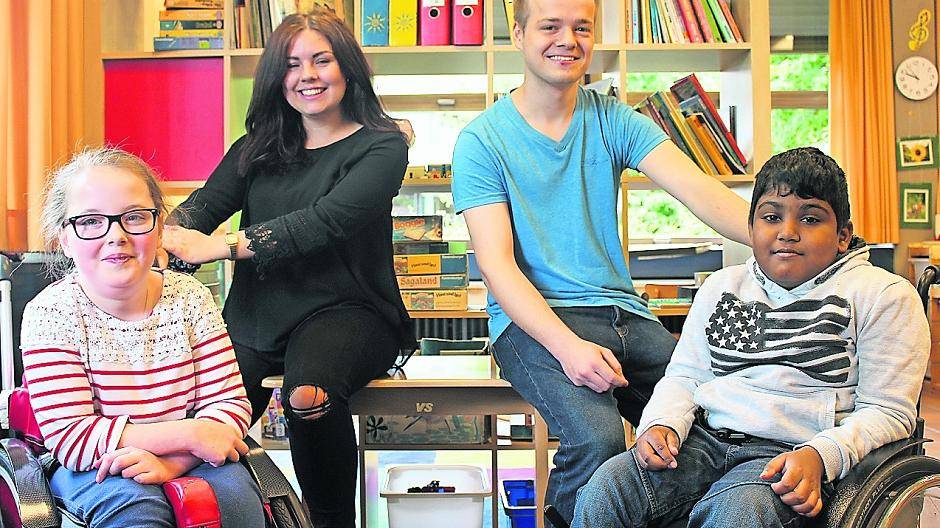 Fröhliches Team: Die jungen Betreuer Sandy und Robin mit zwei ihrer pfiffigen Schützlinge, Kelly (l.) und Kabilash (r.) im Klassenzimmer der Montessori-Grundschule. Es ist mit Lernmaterialien gut bestückt, weil die Montessori-Pädagogik das selbstständige Lernen gezielt fördert.