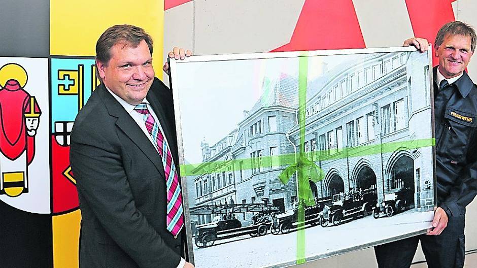  OB Frank Meier und Feuerwehr-Chef Meissner bei der Einweihung der neuen Wache mit einem Bild der alten Wache Florastraße. 