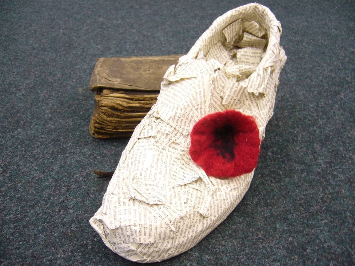 Ein Papierschuh mit Filzblume.