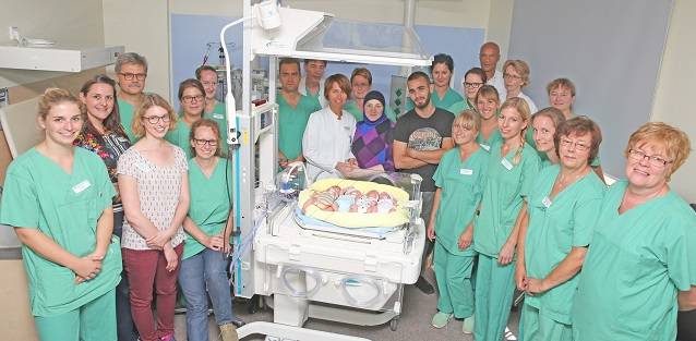 Die glücklichen Eltern mit ihren Vierlingen und dem Ärzte, Hebammen und Pfleger-Team.