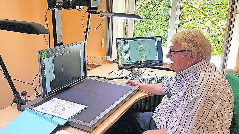 Der Vorsitzende des Sport- und Kulturausschusses, Franz Auling, an den Geräten zur Digitalisierung von Dokumenten des Stadtarchivs.