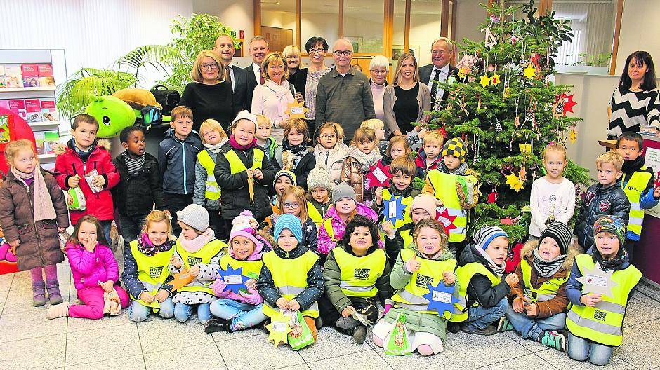 Bürgermeister Josef Heyes (links neben dem Baum) hat am Montag gemeinsam mit den Kindern der Anrather Kindertagesstätten Furthstraße und Huiskenstraße zum Auftakt der Aktion den Baum in der Sparkasse Anrath geschmückt.