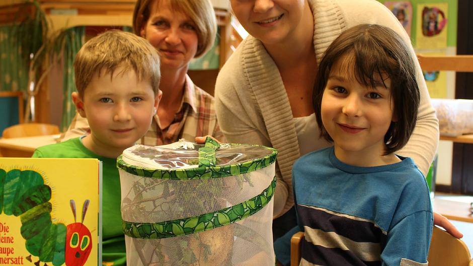 Eifrige Naturforscher: Leon (l.) und Artur (r.) beobachten unter Anleitung von Kindergärtnerin Kerstin Kurdek (r.) im Netzkäfig, wie sich die Raupen entwickeln. Birgit August (l.), Vorsitzende des Krefelder Kinderschutzbundes, freut sich über die intensive Naturpädagogik in der Kita, die in Trägerschaft des Kinderschutzbundes steht.