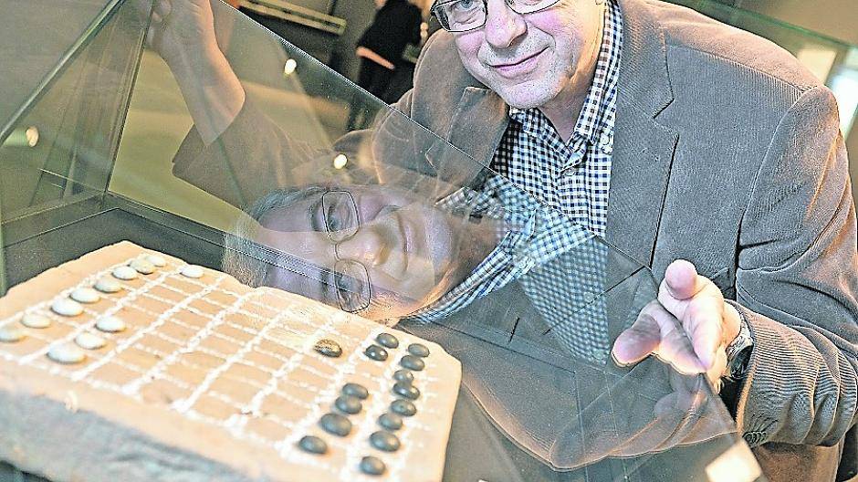 Blick in die Vergangenheit: Museumsleiter Dr. Christoph Reichmann betrachtet in der Vitrine einen römischen Fußbodenziegel aus Gellep mit einem aufgemaltem Spielbrett für das Soldatenspiel.