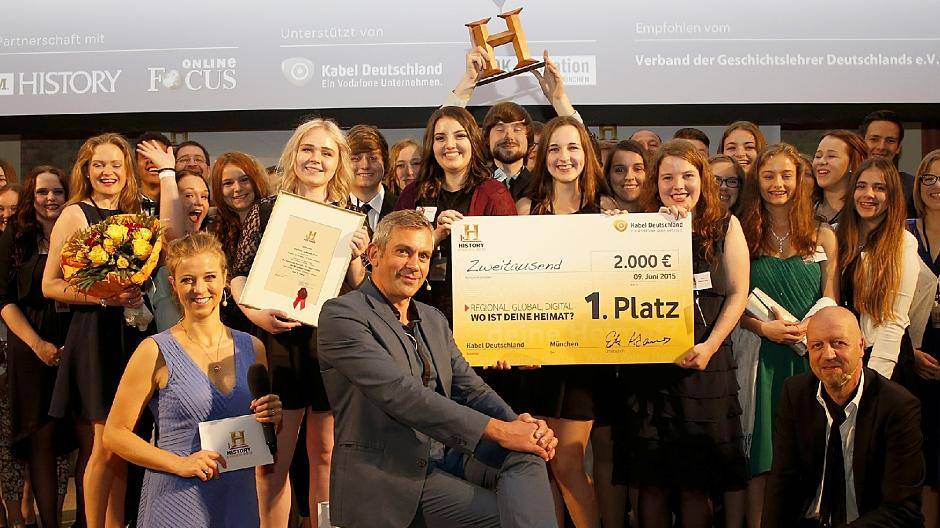 Preisverleihung in München: Wladimir Kaminer (sitzend) freut sich mit den Hülser Schülern, die den ersten Preis beim History-Award gewonnen haben.