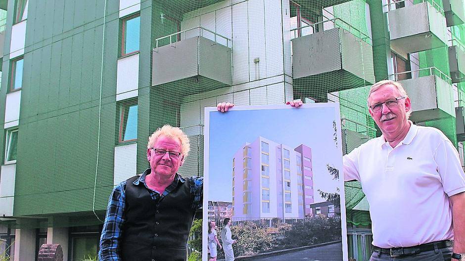  Neuer Look: Heimleiter Heinz-Werner Knoop (l.) und Geschäftsführer Norbert Niessen zeigen vor dem Hintergrund des sanierungsbedürftigen Wohnheimes eine Darstellung der künftigen Fassade des siebenstöckigen Hauses. 