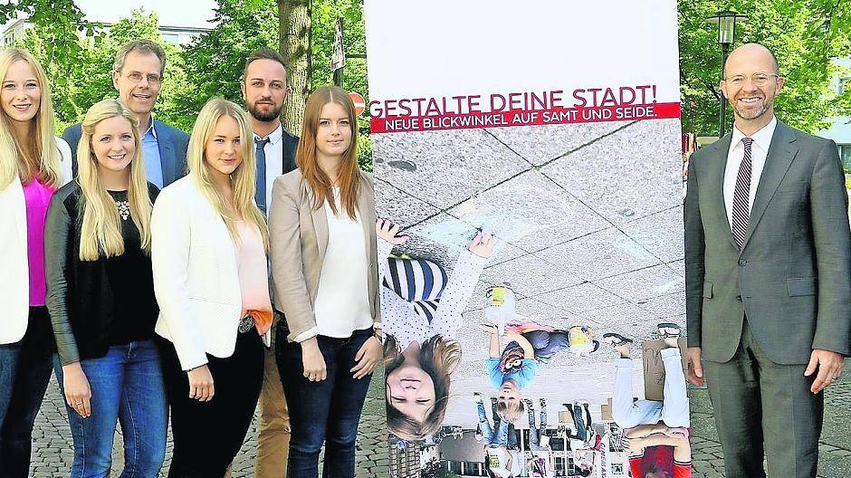  Die Mönchengladbacher Studenten um Professor Harald Vergossen (hinten li.) präsentieren mit Uli Cloos vom Stadtmarketing und Eckart Preen von der Wirtschaftsförderungsgesellschaft ein Werbebanner zum Krefelder Perspektivwechsel. 