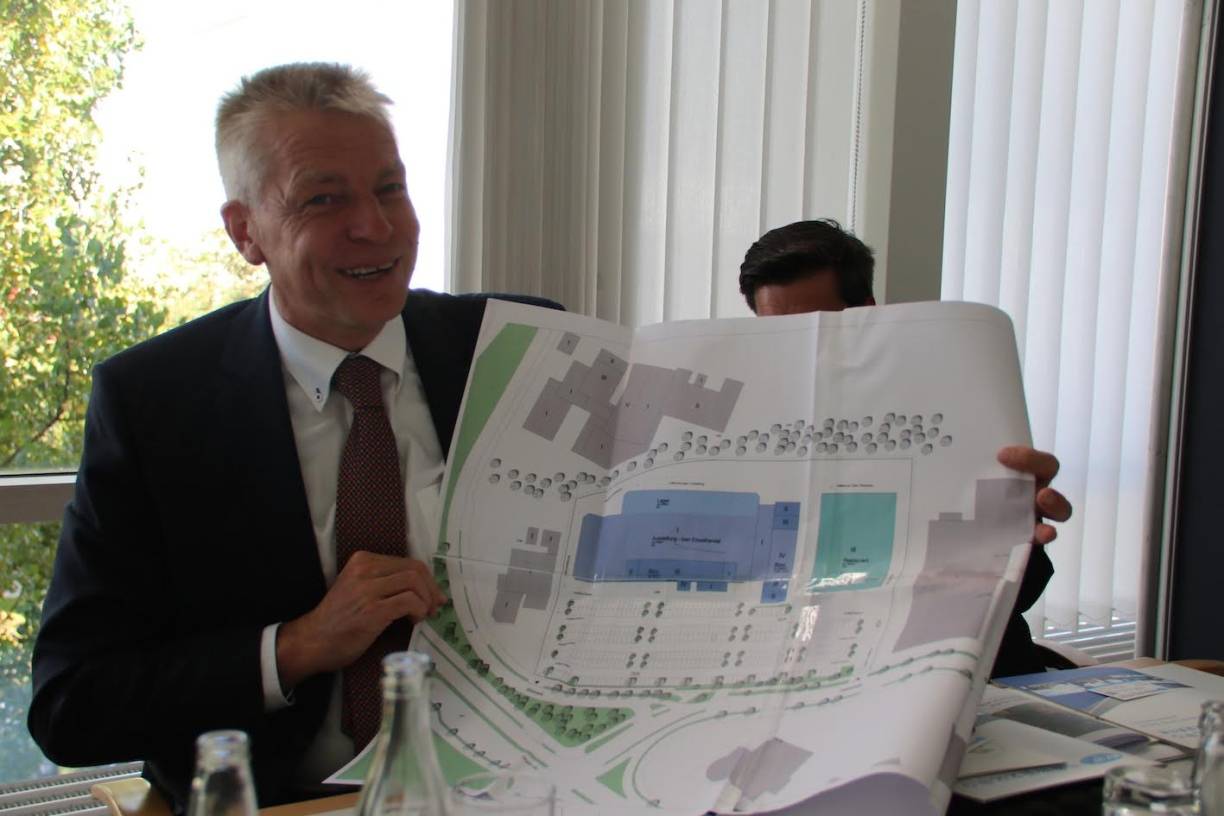 Planungsdezernent Martin Linne zeigt den Plan des ehemaligen Baumarkts und des möglichen Hotel/Restaurant-Anbaus rechts daneben. 