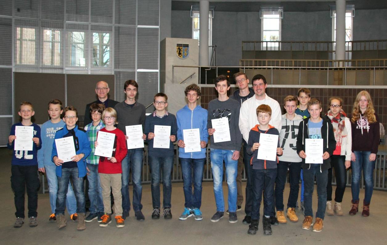  Mathematik als olympische Disziplin für den Nachwuchs: Stolz zeigen die Mathe-Asse aus dem Kreis Viersen ihre Urkunden. Im Zuge einer Feierstunde im Viersener Kreishaus-Forum sind die begabten Schülerinnen und Schüler geehrt worden. Mathe-Olympiade-Koordinator Philipp Schultz (7. v.r.) und Bildungs-Dezernent Ingo Schabrich (5.v.l.) nahmen die vier Erstplatzierten in ihre Mitte (ab Ingo Schabrich von links): Maximilian Wiesmann, Ole Varwick, Nils Rey und Vincent Bröse. 