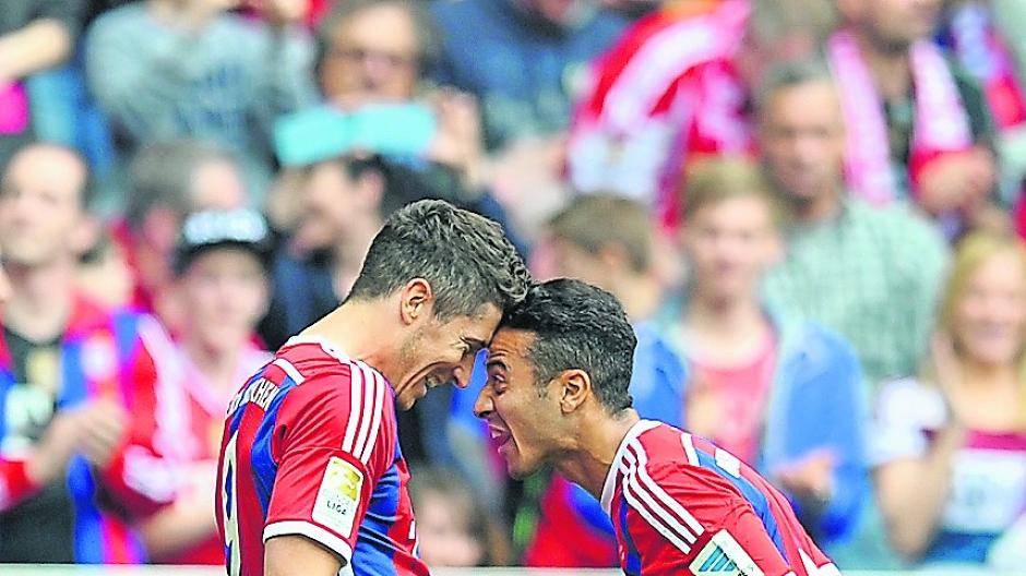 Robert Lewandowski und Thiago bejubeln Kopf-an-Kopf den Sieg ihres Teams.