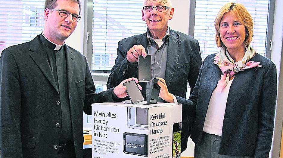 Bürgermeisterin Sabine Anemüller und Pfarrer Helmut Finzel (Pfarre St. Remigius, li.) unterstützen die Handy-Sammelaktion, die von Bernd Bodenbenner (Mitte) initiiert wurde.
