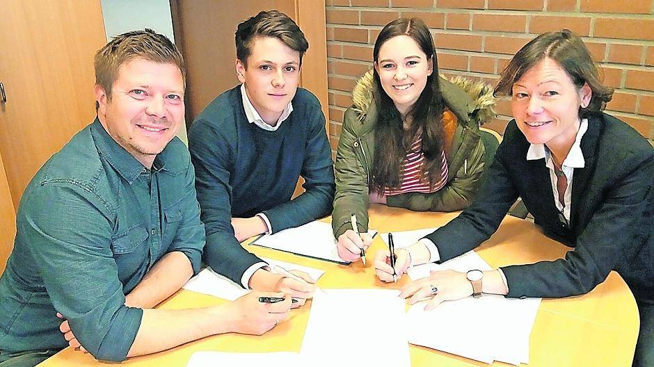 Schulleiterin Eller Hofmann, Schülerin Jaqueline Marzen, Schüler Jan Venten und Lehrer Christian Hlawa (von rechts) unterzeichnen den Vertrag der Schülerfirma „Dein-Betrieb.com“.