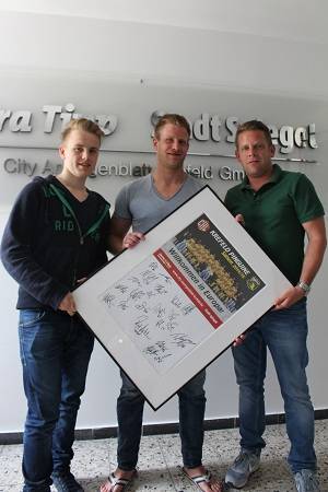 Pinguine-Stürmer Daniel Pietta (Mitte), Extra Tipp-Redakteur Jörg Zellen (rechts) und Praktikant Cedric Oehmen-Klessa (links), der eingefleischter Eishockey-Fan ist, präsentieren das unterschriebene Teamplakat der ersten Champions Hockey League-Saison.