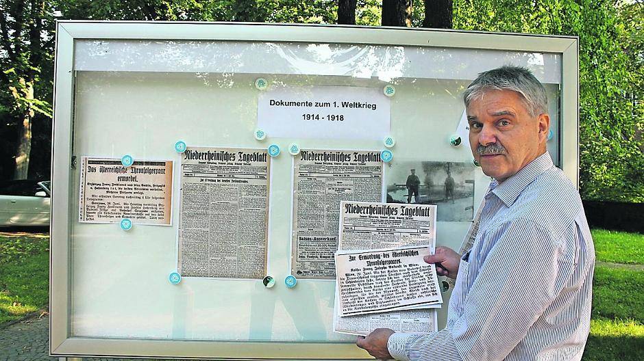 Archivpädagoge Jürgen Grams bestückt den Schaukasten an der Kempener Burg mit Dokumenten zum Ersten Weltkrieg.