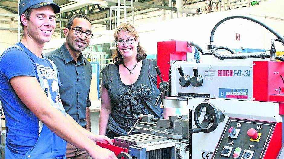  An der Fräsmaschine: Azubi Marc packt in der Junior-Werkstatt des Bahnbetriebswerkes Bockum beherzt zu. Azubi-Koordinatorin Simone Bößing und John Cadmus, Leiter der „Junior-Firma“, überzeugen sich von seinem Können. 