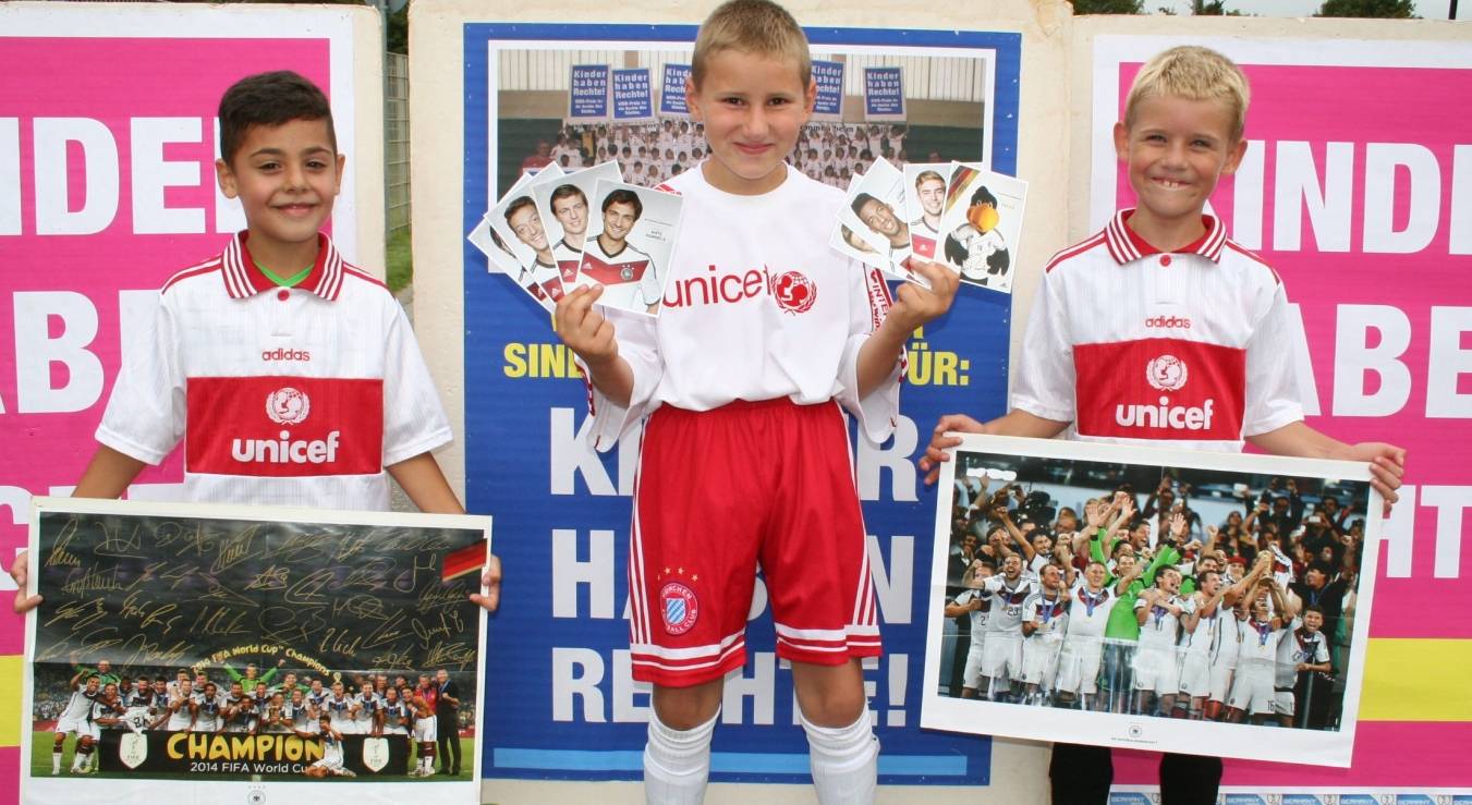 Kinder freuen sich über Autogrammkarten der Weltmeister