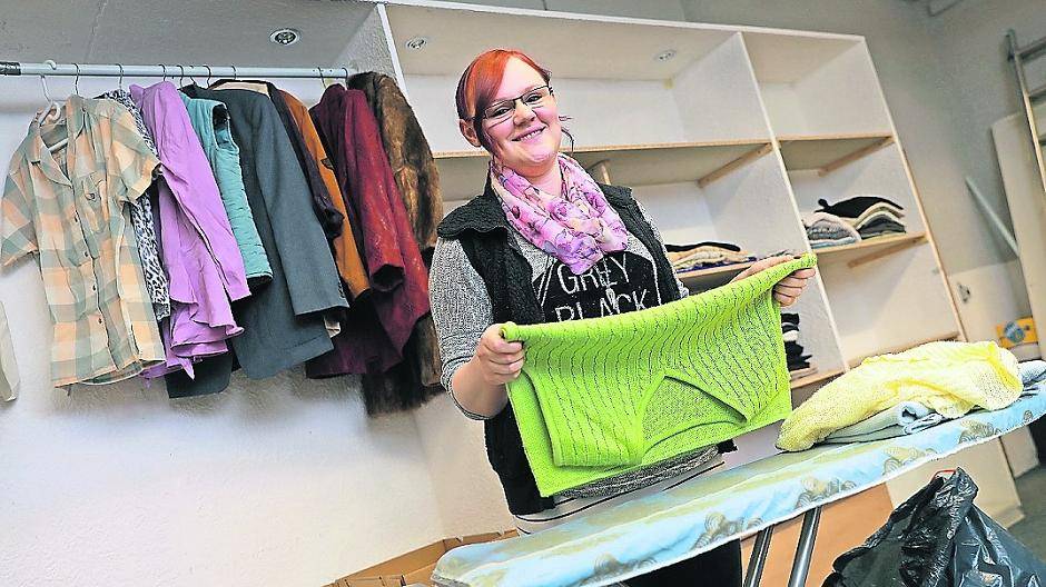  Die Secondhand-Kleider werden sortiert und auf Bügel gehängt. 