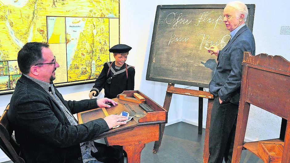  „Ohne Fleiß kein Preis“ steht auf der alten Schultafel im Viersener Salon der Villa Marx. Hier eröffnen heute Kurator René Franken (links) und Dr. Albert Pauly (rechts) die neue Ausstellung: „Kindheit am Niederrhein“. 