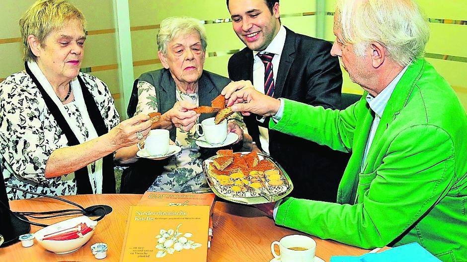 „Moppe“ und Mispelgebäck, zwei typische Köstlichkeiten aus der niederrheinischen Küche. Es greifen beherzt zu (v.l.): Ulla Franken, ihre Mutter Maria, Carsten Zint, Filialleiter der Sparda-Bank Viersen, und Dr. Albert Pauly vom Verein für Heimatpflege Viersen.