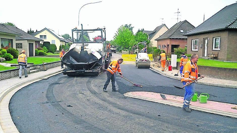 Die Arbeiter der ausführenden Firma Hamelmann aus Tönisvorst bringen die neue Straßendecke auf in Brüggen-Bracht auf. Am Mittwoch, 1. Juni, wurde der Mini-Kreisverkehr freigegeben.