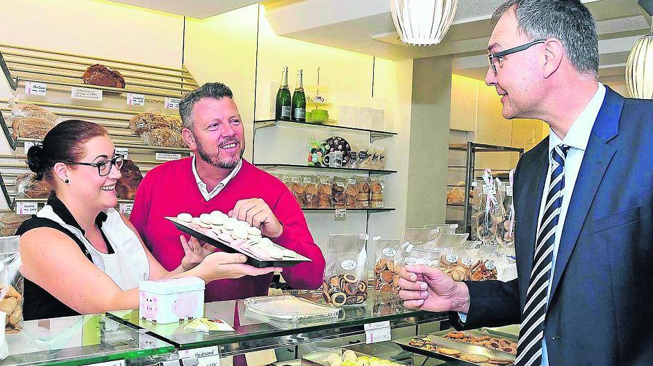  Besonders viel Spaß macht Davina Zerrehsen die Arbeit mit den Kunden. Hier bedient sie symbolisch Franz-Josef Schmitz, Geschäftsführer des Jobcenters. Armin Houben, Inhaber des Café Kerskens, schaut ihr dabei über die Schulter. 