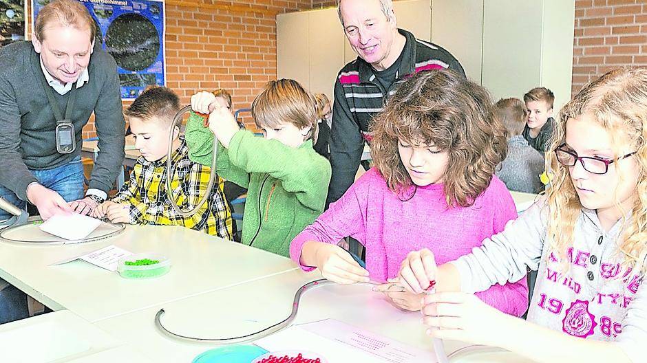  Mit Hilfe von Fragen zum Konsumverhalten und den verschiedenfarbigen Kügelchen ermitteln die Schüler ihren eigenen virtuellen Wasserbedarf — eine Aufnahme in der Gesamtschule Nettetal, Klasse 5c, rechts im Bild: Umweltpädagoge Carsten Schultz, Mitte: Lehrer Georg Stadeler. 