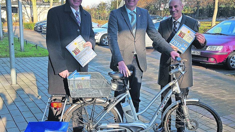 Carsten Thören von der Volksbank Meerbusch und Albert Lopez von den Wirtschaftsbetrieben Meerbusch (wbm) freuen sich mit Michael Assenmacher, Umweltdezernent der Stadt Meerbusch, den Umweltkalender samt neuem „Fahrrad-Shopper“ vorzustellen.