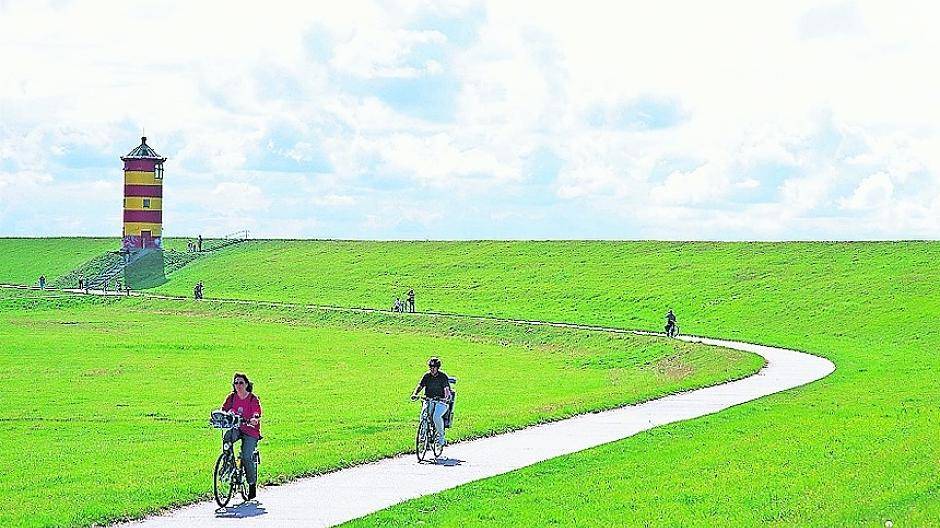  Der gelbrot geringelte Pilsumer Leuchtturm grüßt die Radler auf dem Nordsee-Radweg. 
