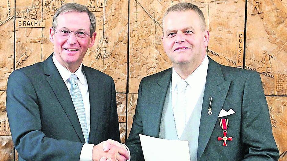 Landrat Peter Ottmann (l.) gratuliert Udo van Neer im Limburgzimmer zum Bundesverdienstkreuz.