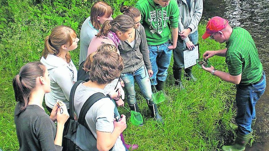 Naturparklehrer Karl-Wilhelm Kolb (r.) mit Jugendlichen an der Schwalm.