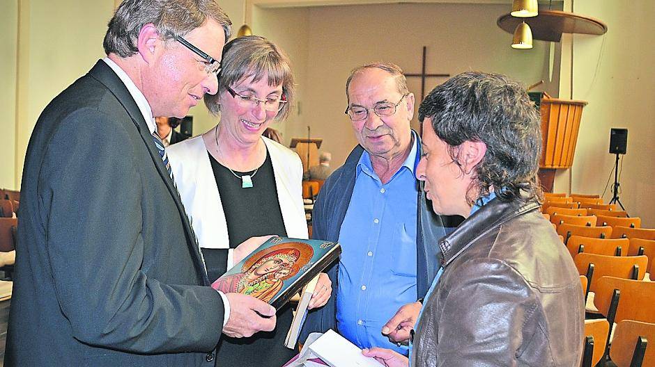 Anthoula Kapnidou und Athanasios Malliaridis (rechts) von der griechisch-orthodoxen Gemeinde schenken Matthias und Beate Engelke (links) zum Abschied eine original Ikone.