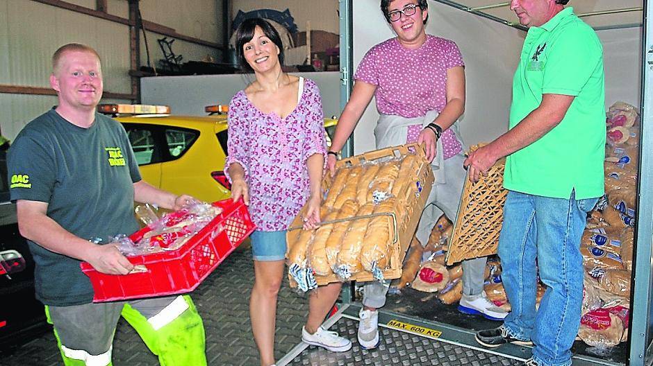 Uwe Bludau vom Abschleppdienst Bröker, Michelle Greiner und Tobias Gerhold von der Flüchtlingshilfe des SKM, die die Flüchtlinge im Kaisers-Hochhaus betreut, und Markus Schmitz (v.l.) konnten das Brot aus dem umgekippten Lkw umladen und an die Flüchtlingshilfe überreichen.