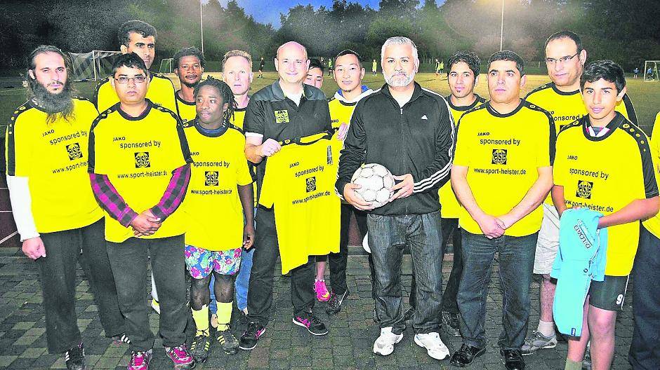 Das stärkt das Zusammengehörigkeitsgefühl: Trainer Meiry Hakimi (5.v.r.) und sein Fußballteam „Sportfreunde Waldniel“ freuen sich über die neuen gesponserten Trikots von Peter Heister (Sport Heister, 7.v.l.) auf dem Platz des SC Waldniel. Fotos (2): Horst Siemes